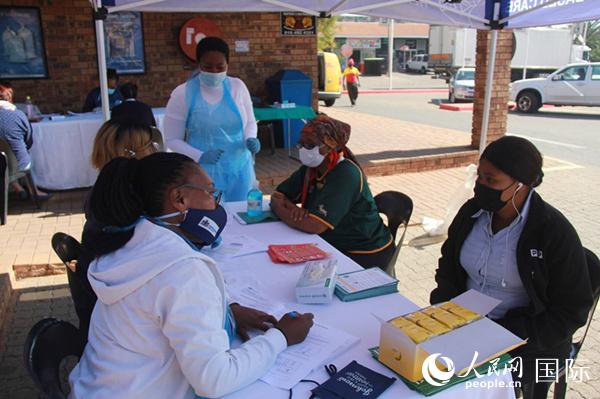 南非西兰德市民众在筛查取样点登记健康状况。摄影万宇